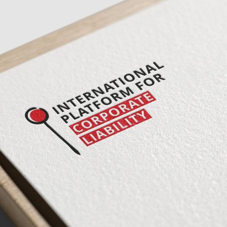 Le logo de l'International Platform for Corporate Liability est présenté en gros plan sur le coin d'un papier à grain. Le logo représente une épingle stylisée, accompagnée du nom de l'institution. Le tout est bicolore : rouge et bleu très foncé.