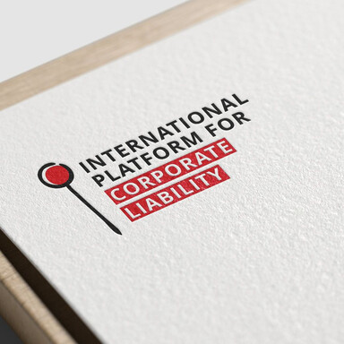 Le logo de l'International Platform for Corporate Liability est présenté en gros plan sur le coin d'un papier à grain. Le logo représente une épingle stylisée, accompagnée du nom de l'institution. Le tout est bicolore : rouge et bleu très foncé.